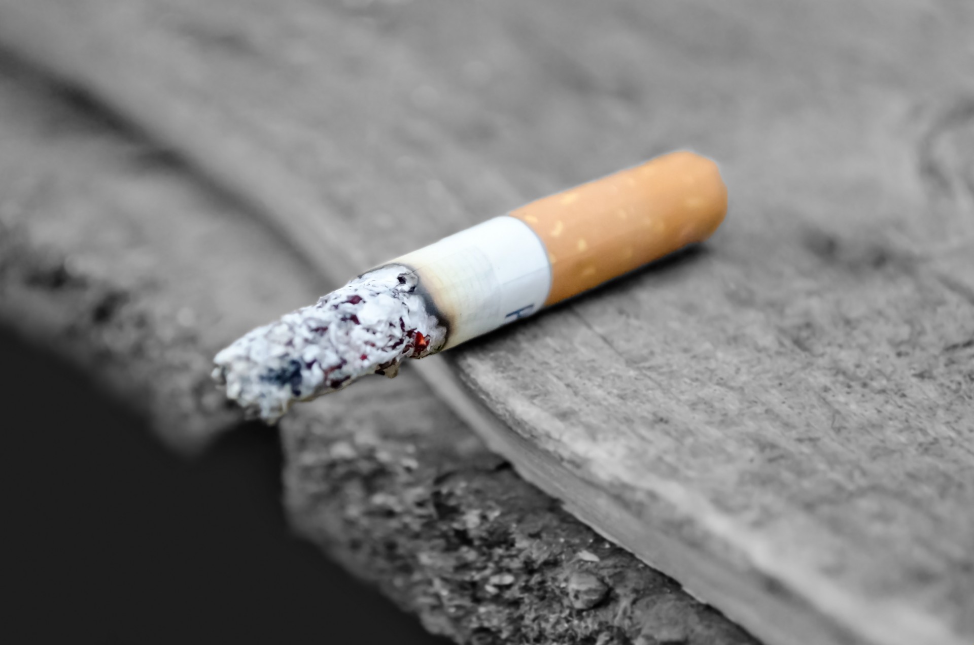 lit cigarette butt on the edge of a table