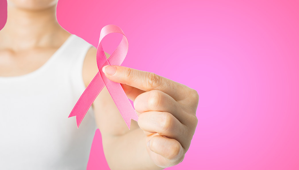 woman holding pink breast cancer ribbon